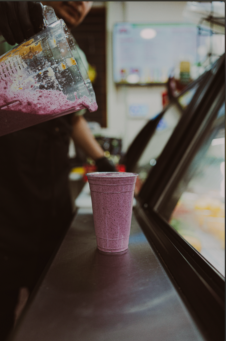 Berry smoothie being blended and served fresh at the counter