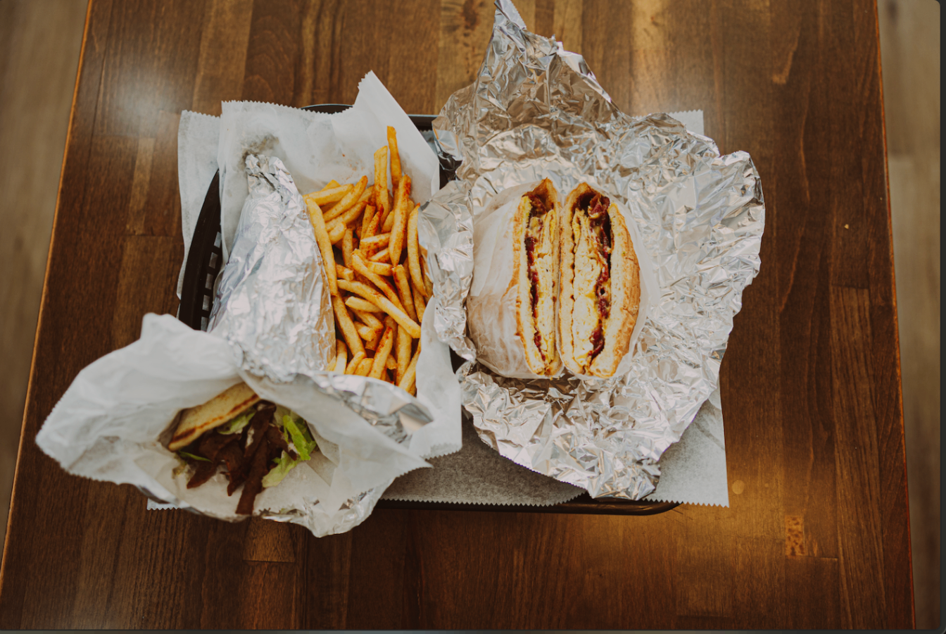 Combo tray with fries and wrapped sandwiches on a wooden table