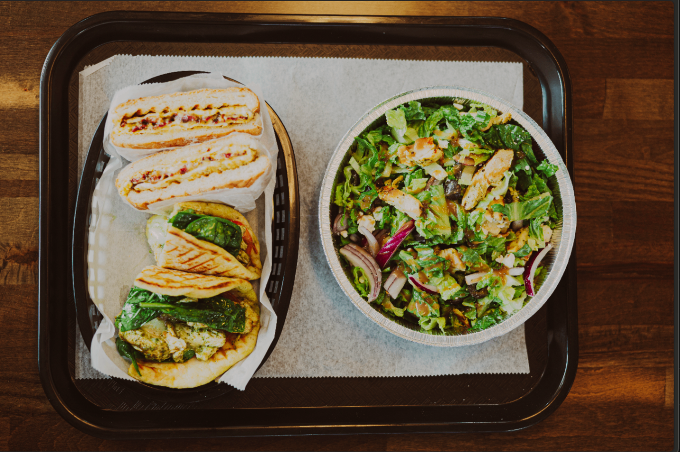 Full deli tray with wraps, panini, and a loaded salad bowl